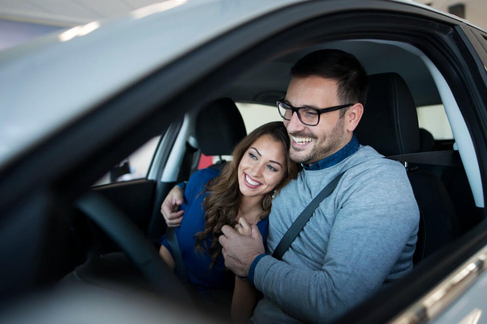 happy-young-couple-enjoying-their-brand-new-car